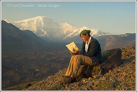 School teacher Natalie keeps up with her reading on the Sanford Plateau trip, July 09, Wrangell - St. Elias National Park, Alaska.