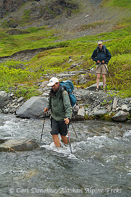 Backpackers crossing a creek in Wrangell-St. Elias National Park and Preserve, Alaska.