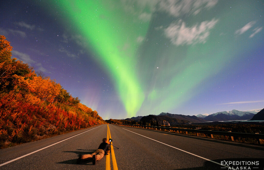 Photographing the aurora borealis in September, surrounded by fall colors, Chugach Mountains, Glenn Highway, Alaska.