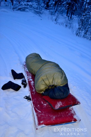 Camper sleeping in a down sleeping bag in Alaska in winter.