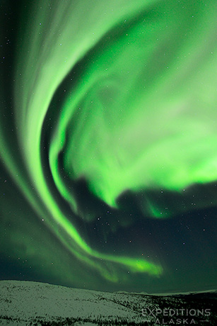 The northern light, or aurora borealis, tower above the White Mountains of arctic Alaska.