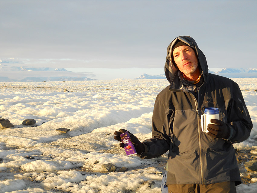 Backpacker with chocolate bar, Malaspina Glacier, Alaska.