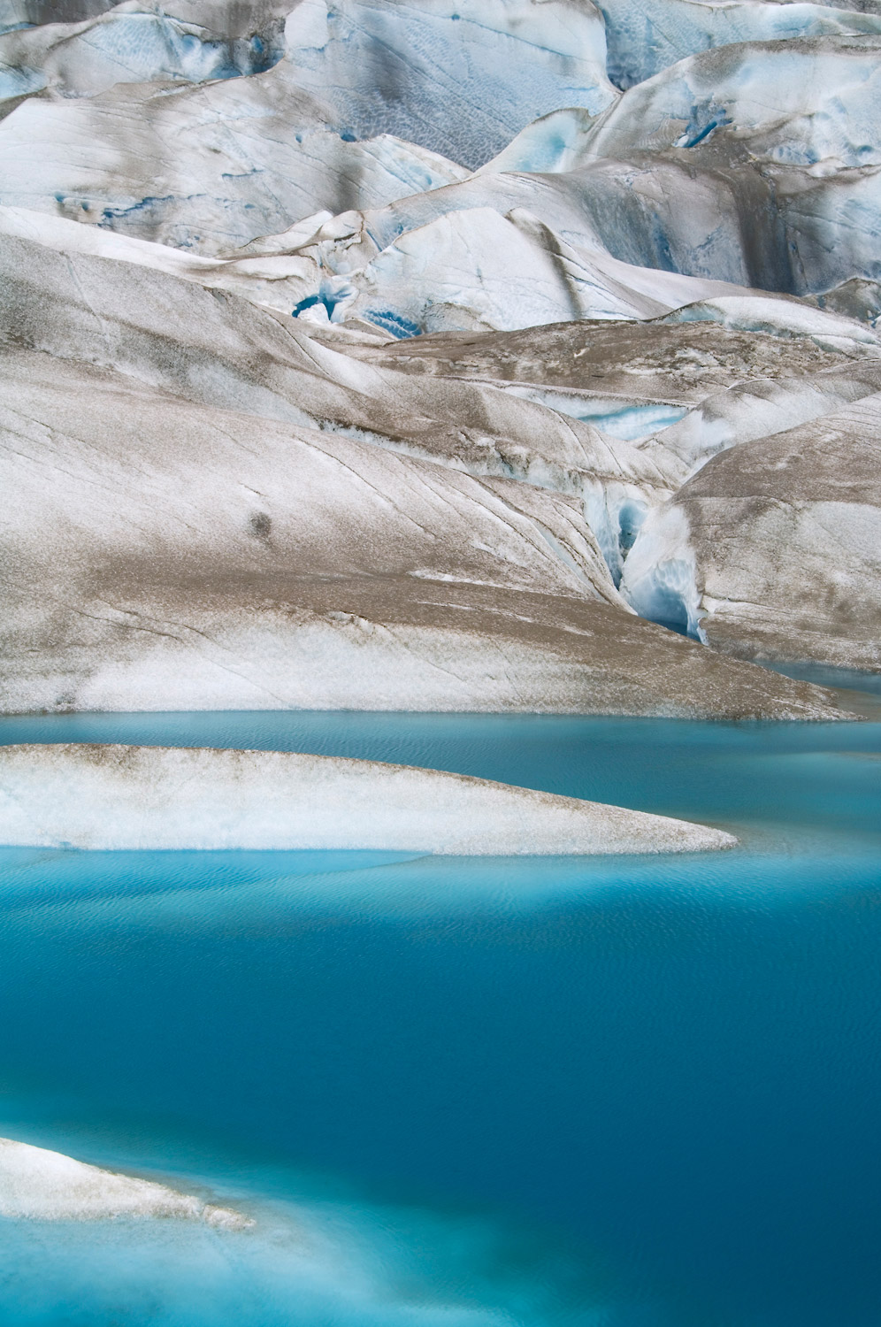 A deep blue tarn, or lake, on Tana Glacier, near Thompson Ridge, Wrangell-St. Elias National Park, Alaska.