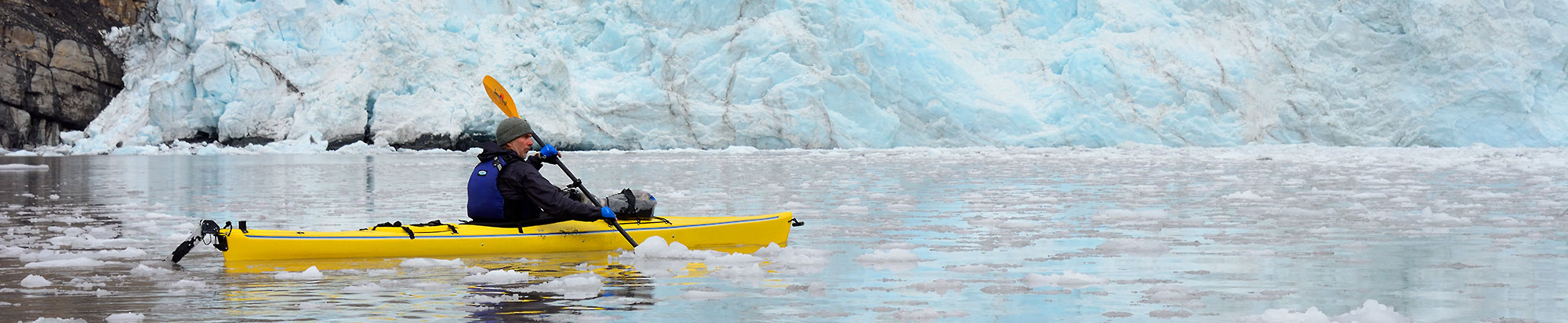 Kayaker and iceberg, Icy Bay, Wrangell - St. Elias National Park, Alaska.