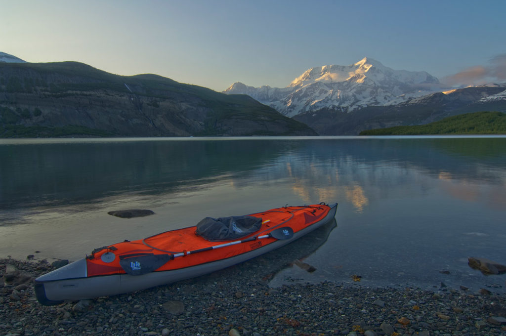 Guided Alaska Sea kayak trip parked on shore with Mt. St. Elias, Icy Bay, Wrangell-St. Elias National Park, Alaska.