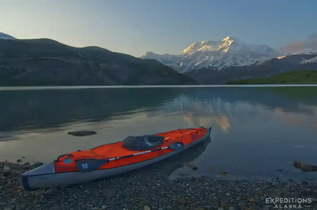 Guided Alaska Sea kayak trip parked on shore with Mt. St. Elias, Icy Bay, Wrangell-St. Elias National Park, Alaska.