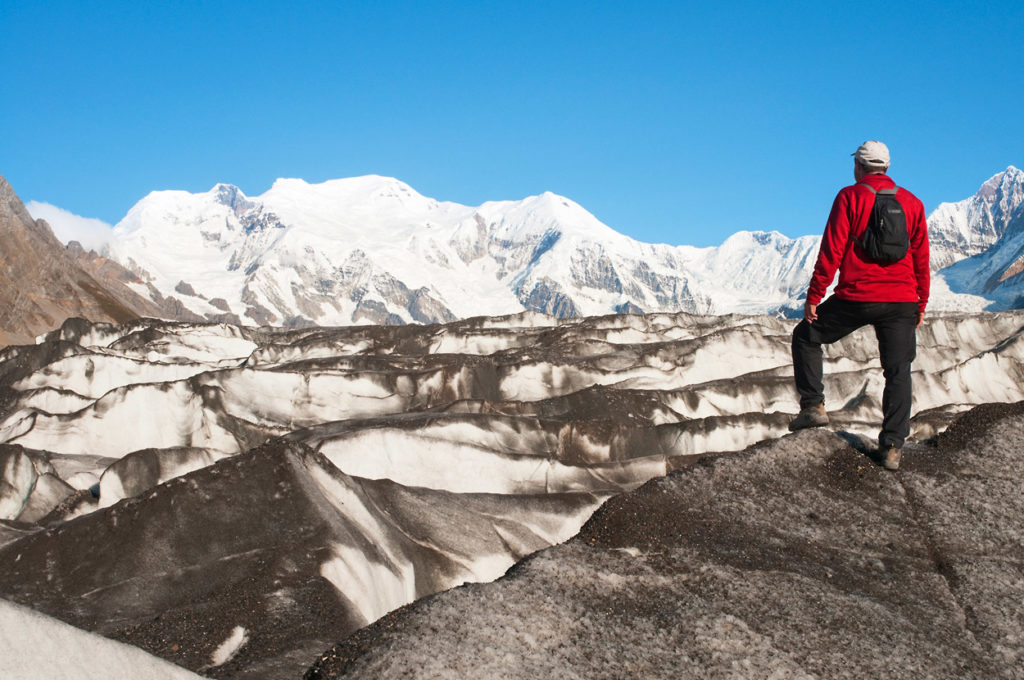 Backpacker hiking on Kennicott Glacier, Wrangell-St. Elias National Park, Alaska.