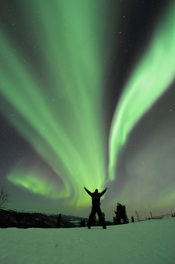 Aurora borealis and a photographer on aurora photo tour in Alaska.