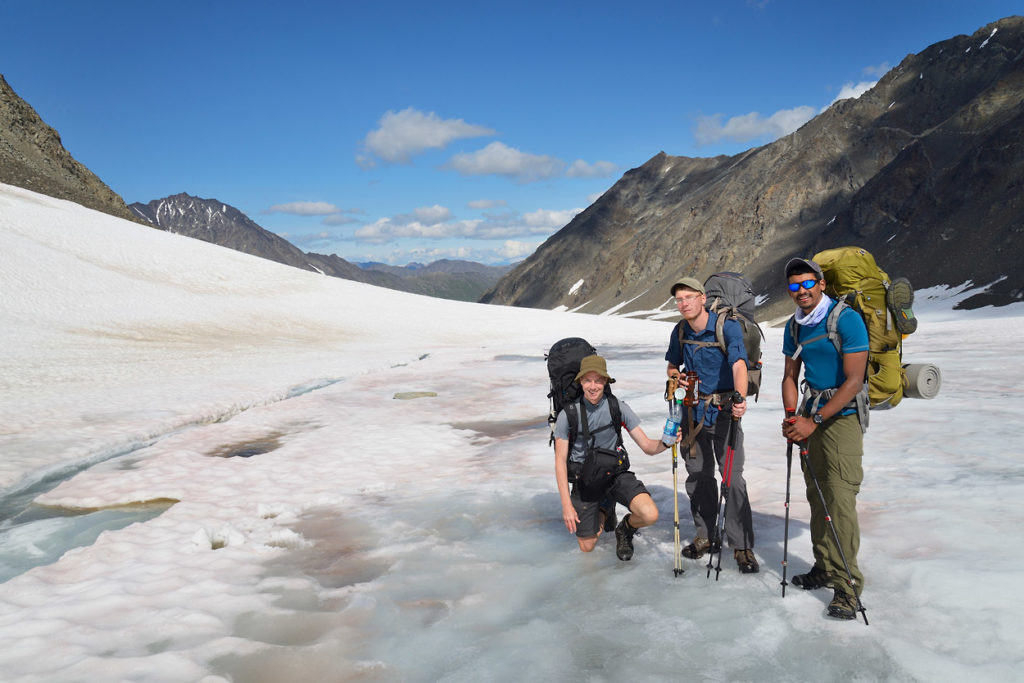 Filling up water bottles on snowfield on Wrangell-St. Elias National Park backpacking trip Alaska.