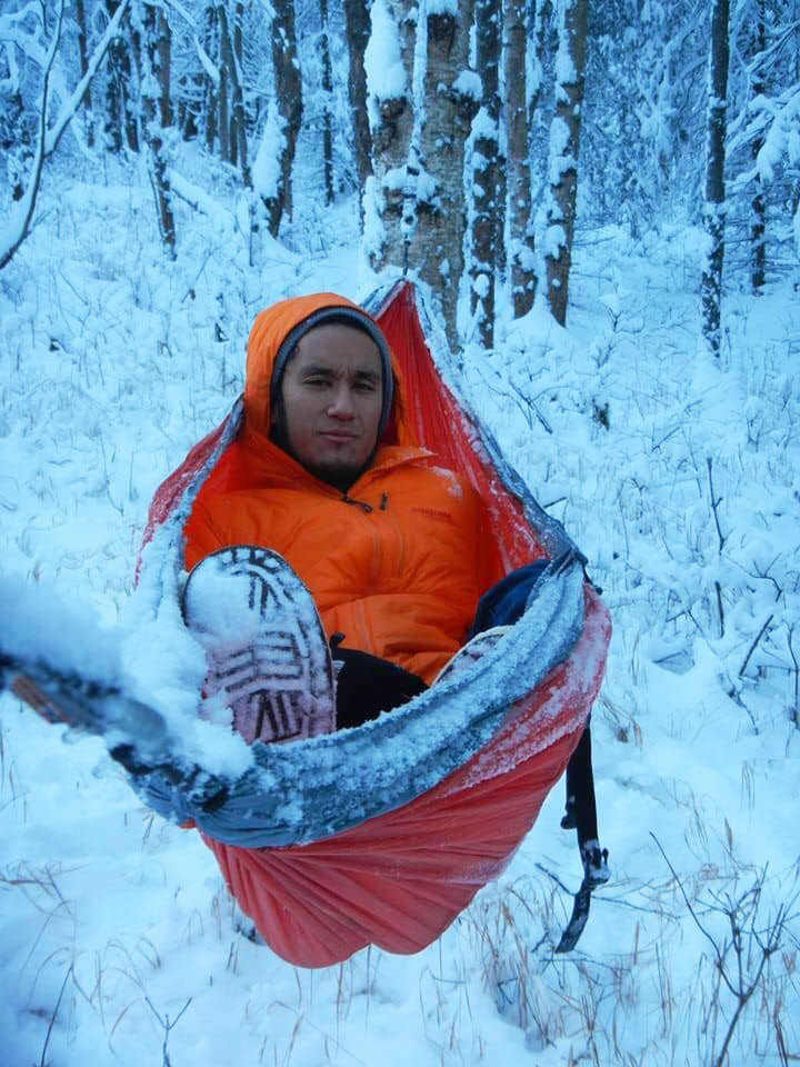 Kevin Enriquez in a hammock in snow.